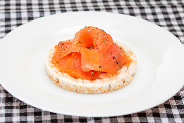 Tasty Rice Cake Sandwich with Fresh Salmon Slices on White Plate. Easy Breakfast and Diet Food....
