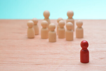 The wooden staff figures stood in unison, representing synergy among teammates, symbolizing the cohesive force within the company, as they awaited guidance from their boss.