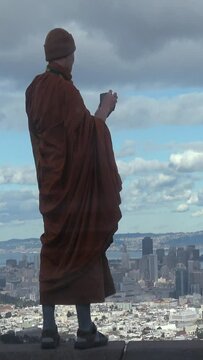 Buddhist monk overlooking the city. Vertical design in 9:16 ratio. Smartphone and social media ready	