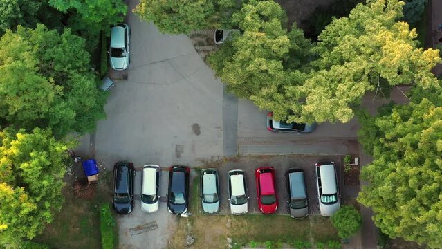 Car looking for parking space. No empty parking box. Aerial drone top-shot. Car turning to side on the road corner. Full capacity.