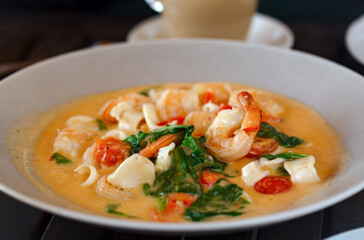 King prawns with samphire. Seafood with steamed prawns  with creamy sauce and basil served in white plate. Seafood concept, selective focus. Delicious shrimps served with slices of greens in cream