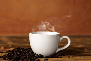 Hot coffee mug, with coffee beans, placed on a wooden table