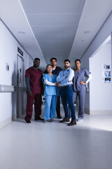 Fototapeta premium Portrait of diverse male and female doctors standing in hospital corridor