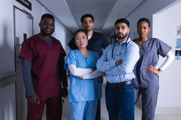 Portrait of diverse male and female doctors standing in hospital corridor