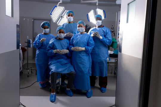 Portrait of diverse male and female doctors wearing face masks in hospital operating room