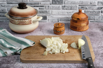 onion chopped into large cubes using a knife on a wooden cutting board © Alex