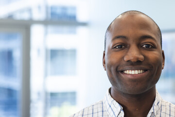 Portrait of happy african american man in hospital waiting room with copy space