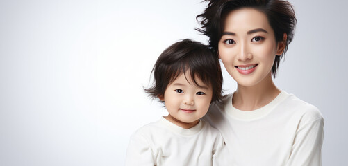 Fashion smiling mother holding her kid on solid color background, love concept