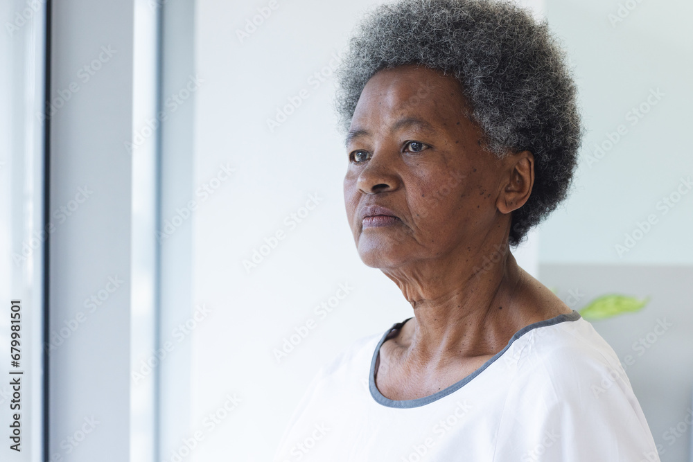 Wall mural African american senior female patient looking out window in hospital room