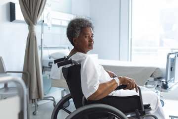 African american senior female patient in wheelchair in sunny hospital room