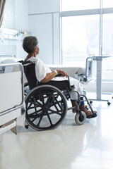 African american senior female patient in wheelchair in sunny hospital room