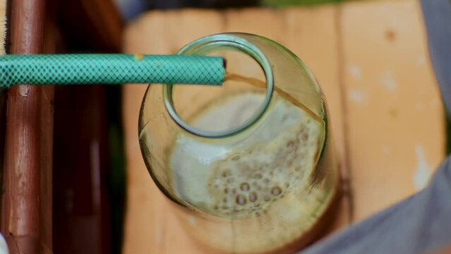 High-angle shot of Fresh apple juice coming out of a pipe in the juice glass jars