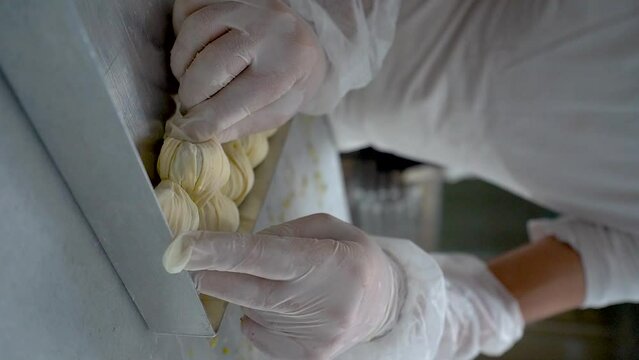 The Turkish pastry chef places pieces of oyster baklava (Midye Baklava) in the tray. Slow motion video, portrait video