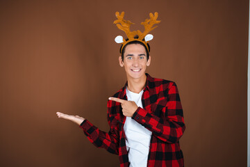 Christmas and New Year. A young attractive guy waiting for the holidays. Brown background.