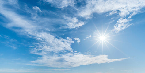Strahlender Sonnenschein und mittelhohe Wolkenfelder am blauem Himmel, perfekter Blendenstern