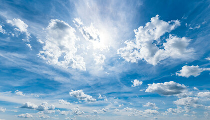 Blauer Himmel mit kleinen Haufenwolken, hohen Cirruswolken und Sonnenschein