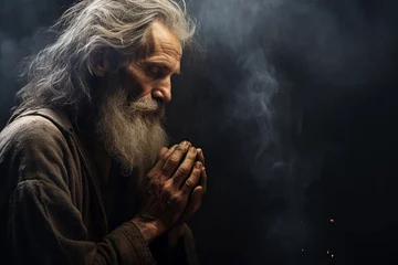 Foto op Plexiglas Old man praying in the dark room with his hands folded in prayer © Oksana