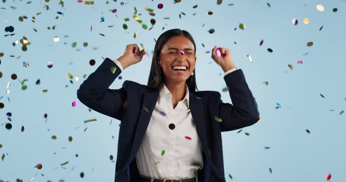 Confetti, celebration and business woman in studio with success, good news and promotion bonus. Excited, fist pump and person with decoration for victory, achievement and winning on blue background