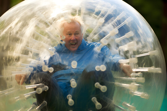 elderly retired man white zorbing enjoying an active and fun lifestyle in retirement