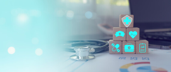 Medical icons on a wooden cube for health insurance concept in hospital background.