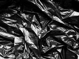 Abstract Texture Crumpled Polyethylene Black Background,Pattern Crease Plastic Bag with Sun Shine Backdrop,Film Wrap Grunge,Overlay Poster Tape Card Foil Paper Sticker Mockup Pack Wrapper.