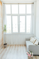 Interior of a white room with an office sofa and a large window