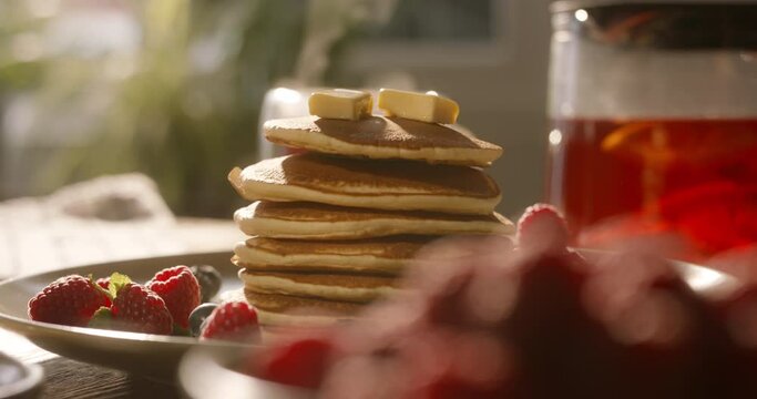 Sprinkling sugar powder onto mouthwatering stack of pancakes. No people, advertising cinematic. Guilt-free cheat meal with tasty and healthy gluten-free recipes and food options. Balance in life