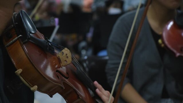 Violin player drops the instrument down to listen to the conductor after attacking some notes, Violin Player