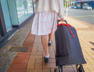Senior woman pulling her shopping bag with wheels