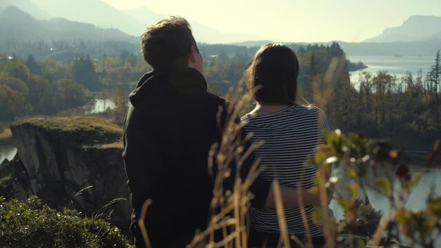 Young couple sitting in the cascades kissing on the cheek
