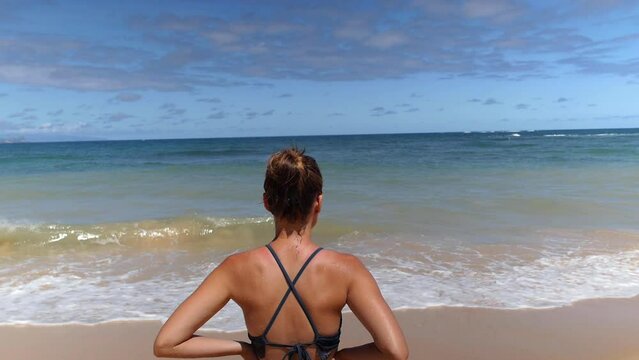 Young petite girl in bikini at the beach in hawaii