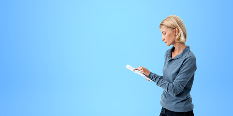 Serious young woman using tablet computer