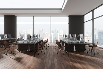 Modern office interior with seats, pc monitors and desk in row near window