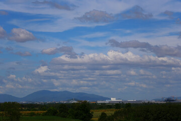 View of meadow and city view with a backdrop of mountains.