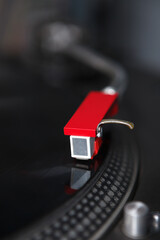 Red needle cartridge on a tonearm of a turntable. Vinyl record player device
