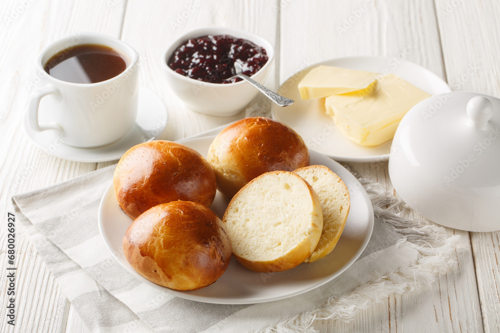 Canvas Prints norwegian boller or hveteboller buns served with butter, jam and coffee closeup on the wooden table.