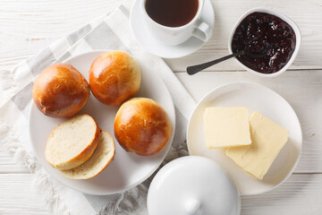 Soft and Delicious Norwegian Boller Cardamom buns served with butter, jam and coffee closeup on the...