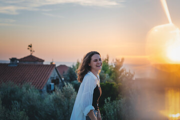 Young cheerful woman enjoying a beautiful moment at sunset. Joy of life concept
