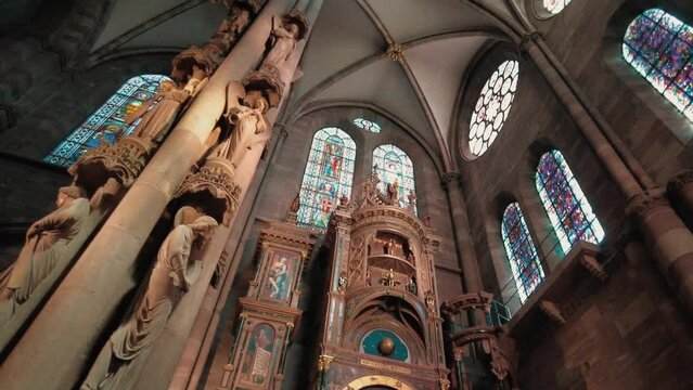 huge pillar with angle statues before astronomical Clock inside Notre dame cathedral Strasbourg. wide angle tilt camera move