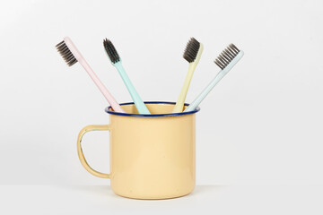 colorful toothbrushes in old retro mug