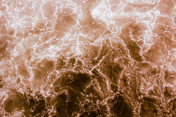 Bright brown water surface with waves and reflections, abstract background in retro style