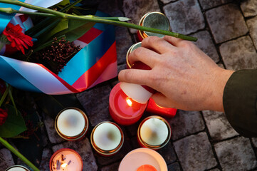 A hand lighting a candle at the November 17th 1989 memorial plaque on Narodni trida