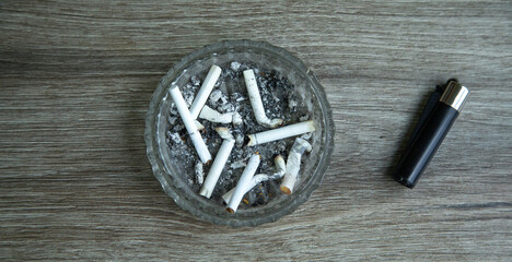 Ashtray, cigarettes and lighter on the table.