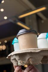 a girl holds a one-cup craft coffee cup