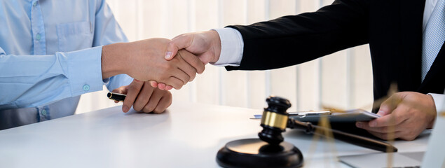 Businessman and corporate lawyer make successful deal with handshake in law firm office. Attorney...