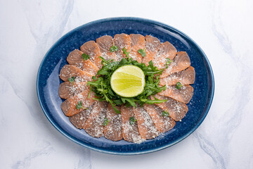 Salmon carpaccio with Parmesan, arugula and lemon  