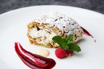 sweet sponge dessert with raspberries and powdered sugar side view