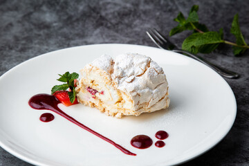 meringue roll with drops of berry jam side view