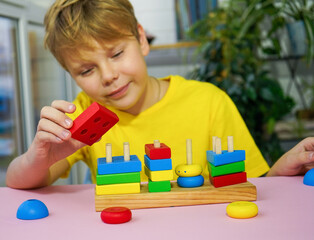 eco wooden toys. The child collects a sorter. Educational logic toys for kids. Montessori Games for Child Development