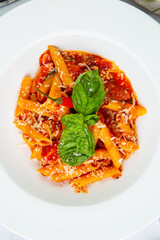 pasta in tomato sauce with cheese and herbs top view